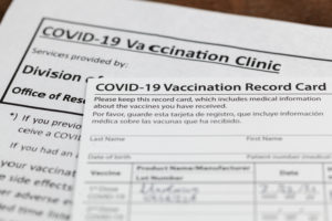 Close up image of COVID-19 vaccination record card and informational papers